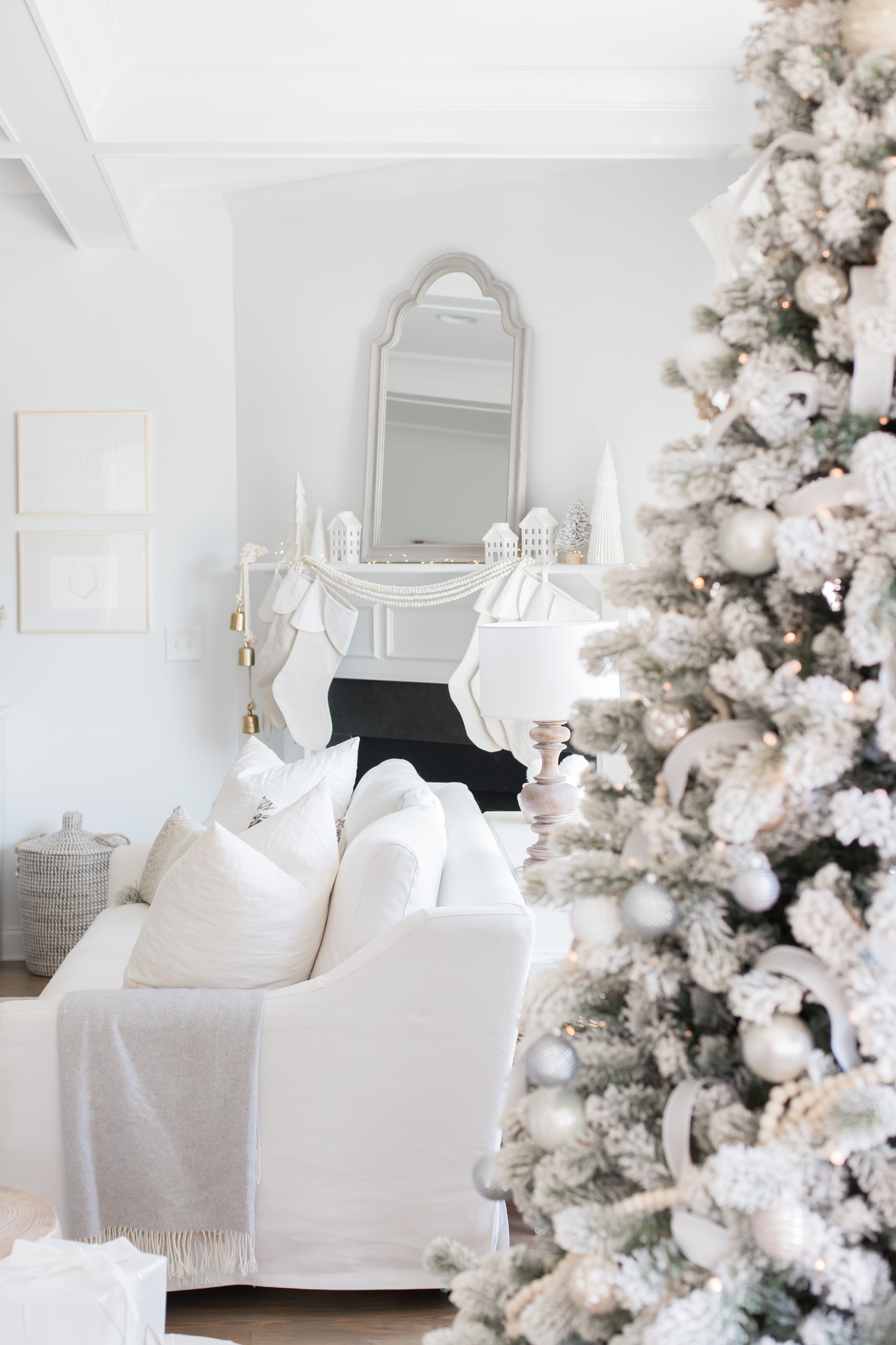 Love this Neutral Christmas Living Room decor. White couches and wood coffee table are beautiful. | AE HOME STYLE LIFE | #christmasdecor #whitechristmasdecor #woodchristmasdecor #whitechristmas #neutralchristmasdecor #christmasmantle #mantledecor #flockedchristmastree #flockedtreedecor #whitecouch 